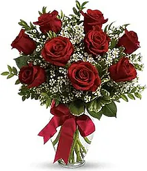 Nine Highest Quality Red Roses decorated with seasonal greenery