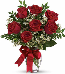 Seven Highest Quality Red Roses decorated with seasonal greenery
