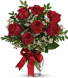 Sette Rose Rosse Big in Elegante Confezione a Tono con Verde Decorativo di Stagione