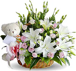 Cesto di gigli o lilum, lisianthus e fiori misti dai toni chiari con peluche