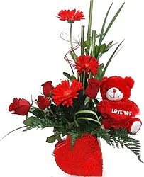 Bowl of roses, gerberas and mixed flowers in warm colors with a plush