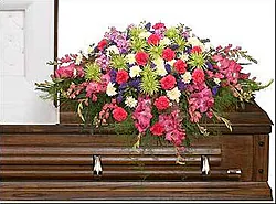 Bright funeral spray of carnations and mixed flowers