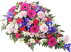 Cuscino funebre di gerbere, garofani e fiori misti dai toni accesi