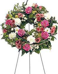 Bright funeral wreath of roses, carnationans, daisies or gerberas and mixed flowers