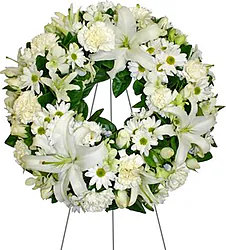 Corona funebre di gigli o lilium, margherite o gerbere, garofani e fiori misti dai toni chiari