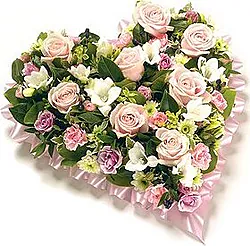 Cuore funebre di rose, garofani e fiori misti dai toni delicati