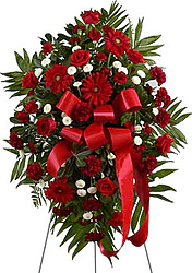 Funeral spray of roses, gerberas and mixed flowers in warm colors