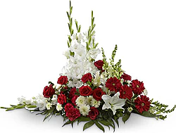 Cuscino funebre di rose, gerbere, lilium e fiori misti dai toni bianchi e rossi