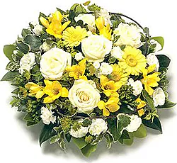 Cuscino funebre di rose, gerbere, garofani e fiori misti dai toni gialli e bianchi